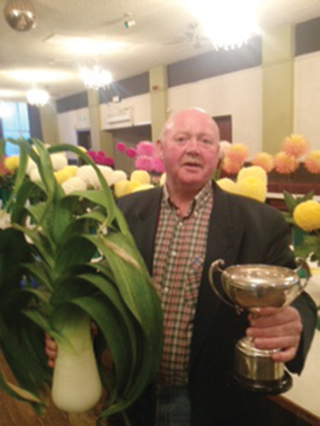 Barry Woodward with one of his prize leeks and trophy.