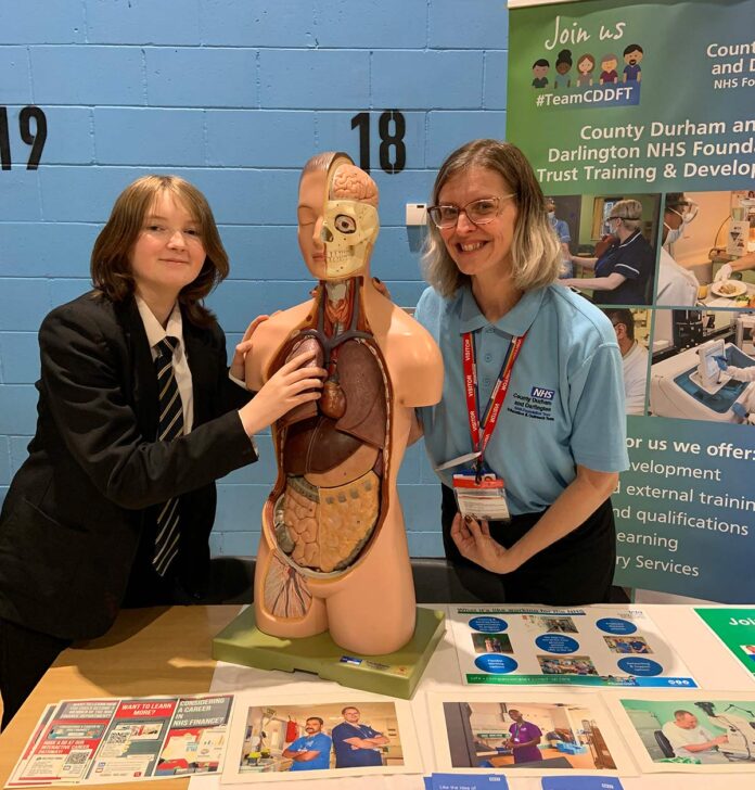 Year-11-student,-Georgia-tries-out-the-NHS-learning-activity-at-the-Careers-Fair